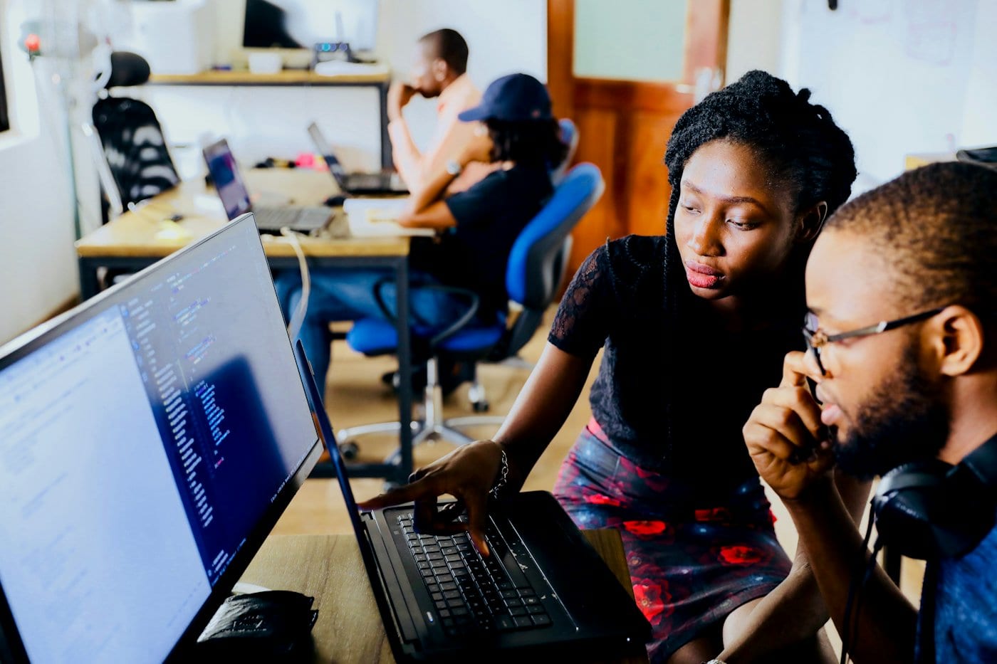 Two colleagues reviewing code on a screen