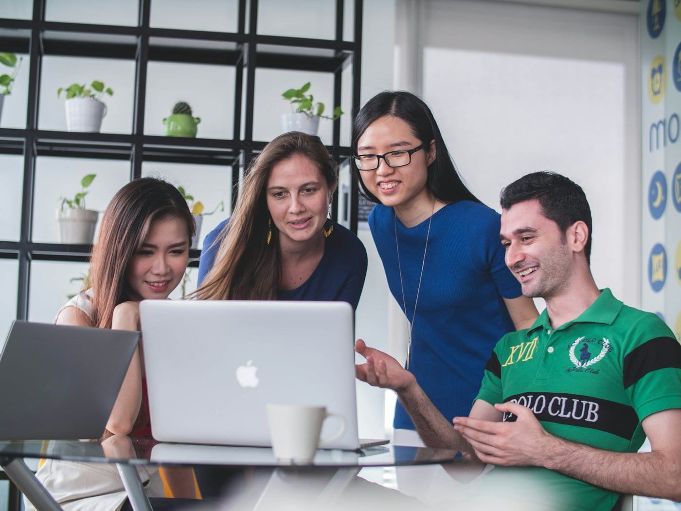 Colleagues gathered around a laptop